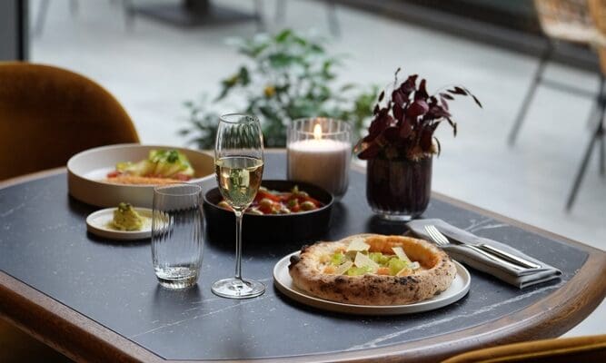 A,Restaurant,Table,With,A,Pizza,,A,Glass,Of,White